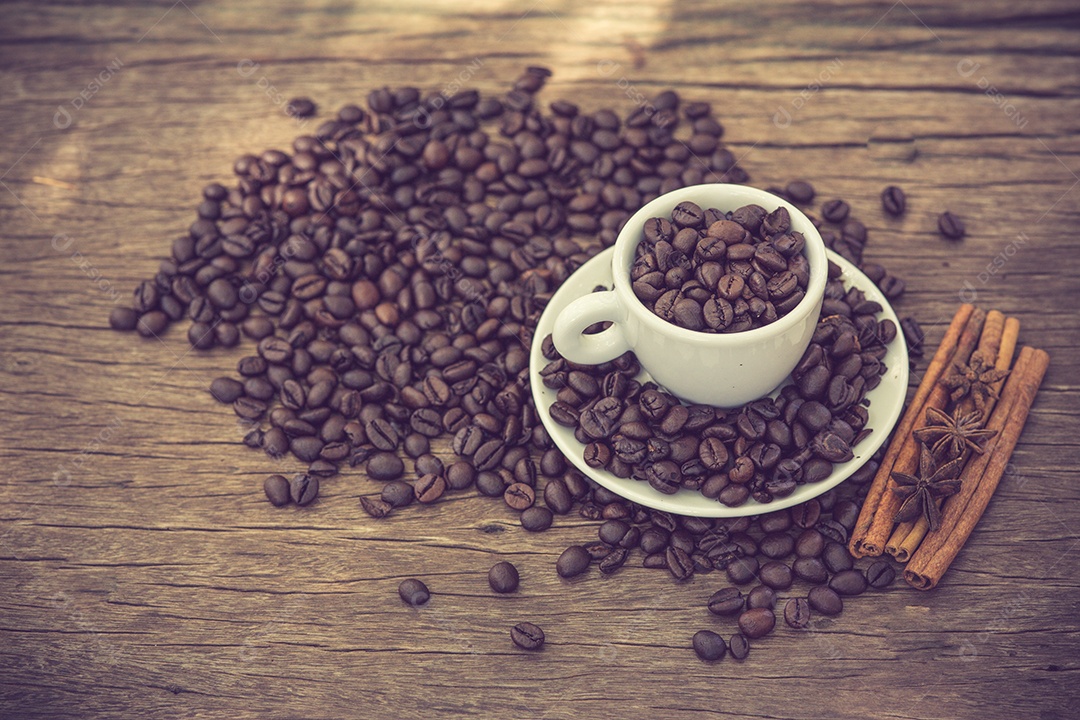 Xícara de café e grãos de café em uma mesa de madeira.