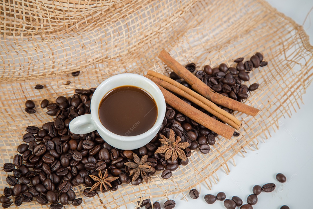 Xícara de café e feijão em um fundo branco.
