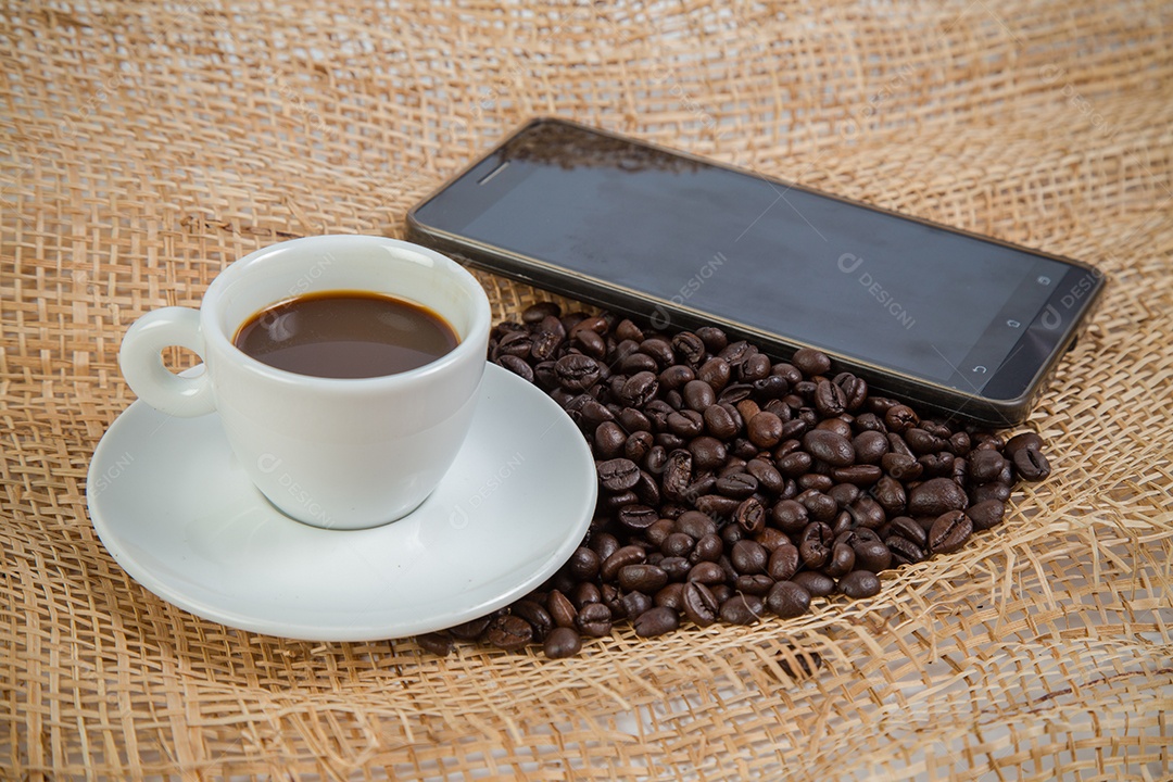 Xícara de café e feijão em um fundo branco.