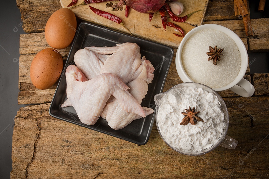 As asas de frango com especiarias - pronto para cozinhar.
