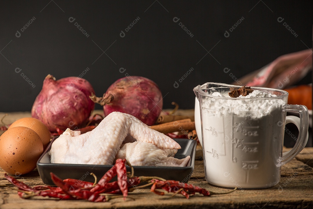 As asas de frango com especiarias - pronto para cozinhar.