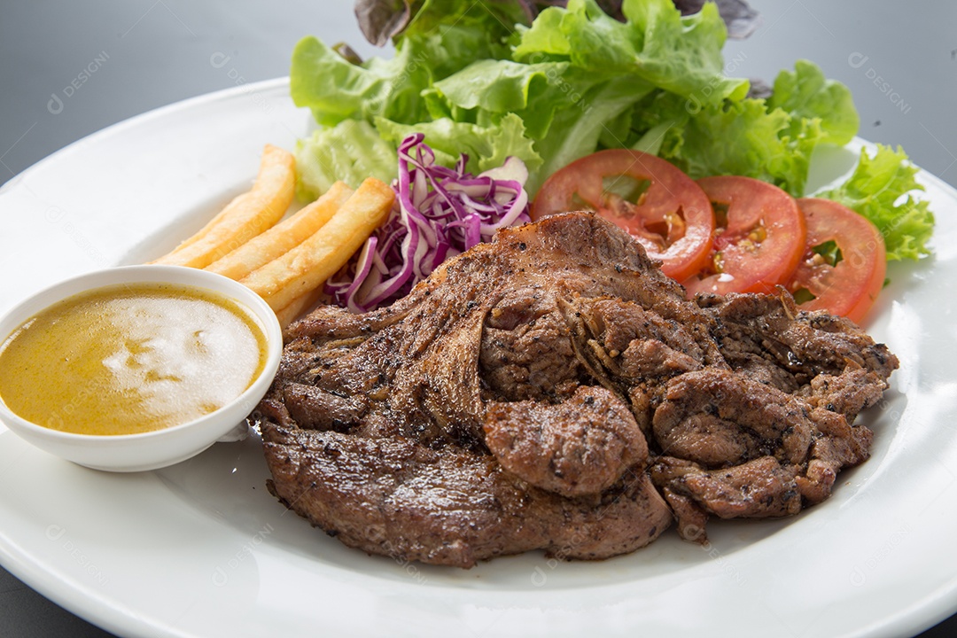 Prato branco de comida bife sobre uma mesa de restaurante