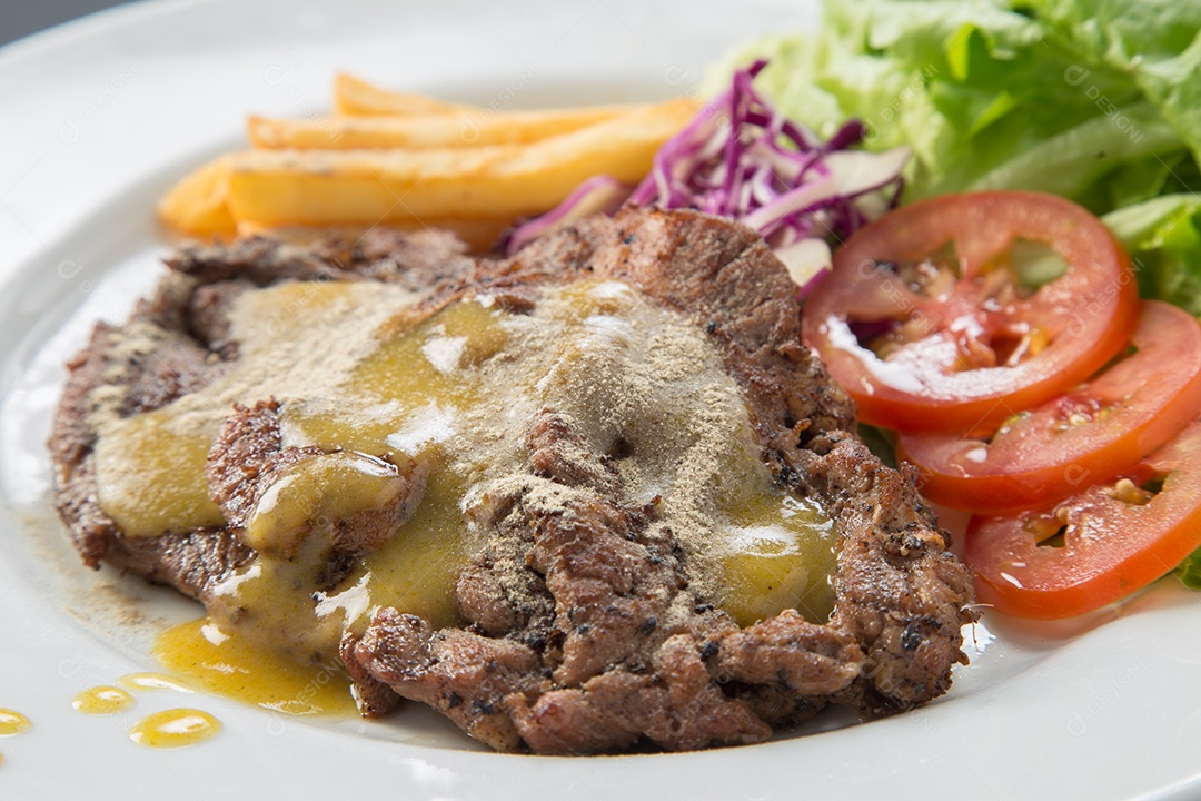 Prato branco de comida bife sobre uma mesa de restaurante