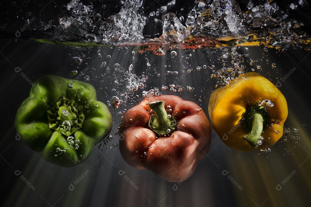 Vegetais espirram água no fundo preto.