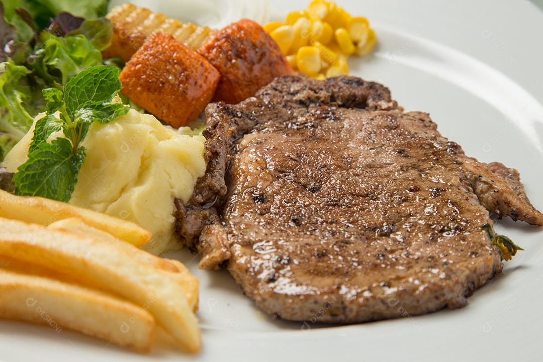 Prato branco de comida bife sobre uma mesa de restaurante