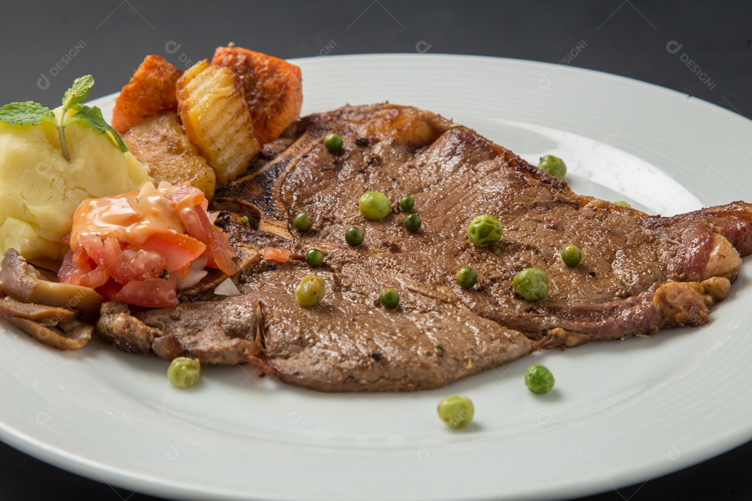 Prato branco de comida bife sobre uma mesa de restaurante