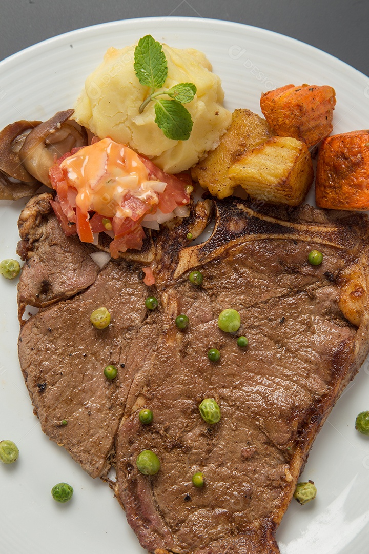 Prato branco de comida bife sobre uma mesa de restaurante
