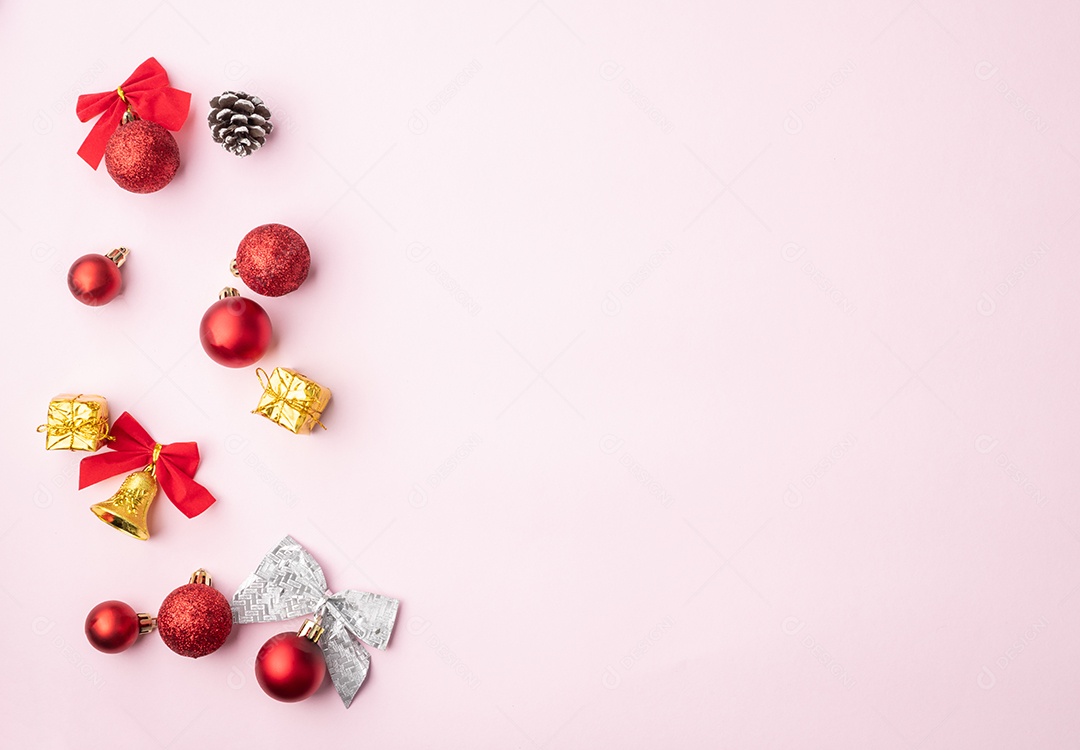 Christmas baubles, bows and pine cones on a light pink background