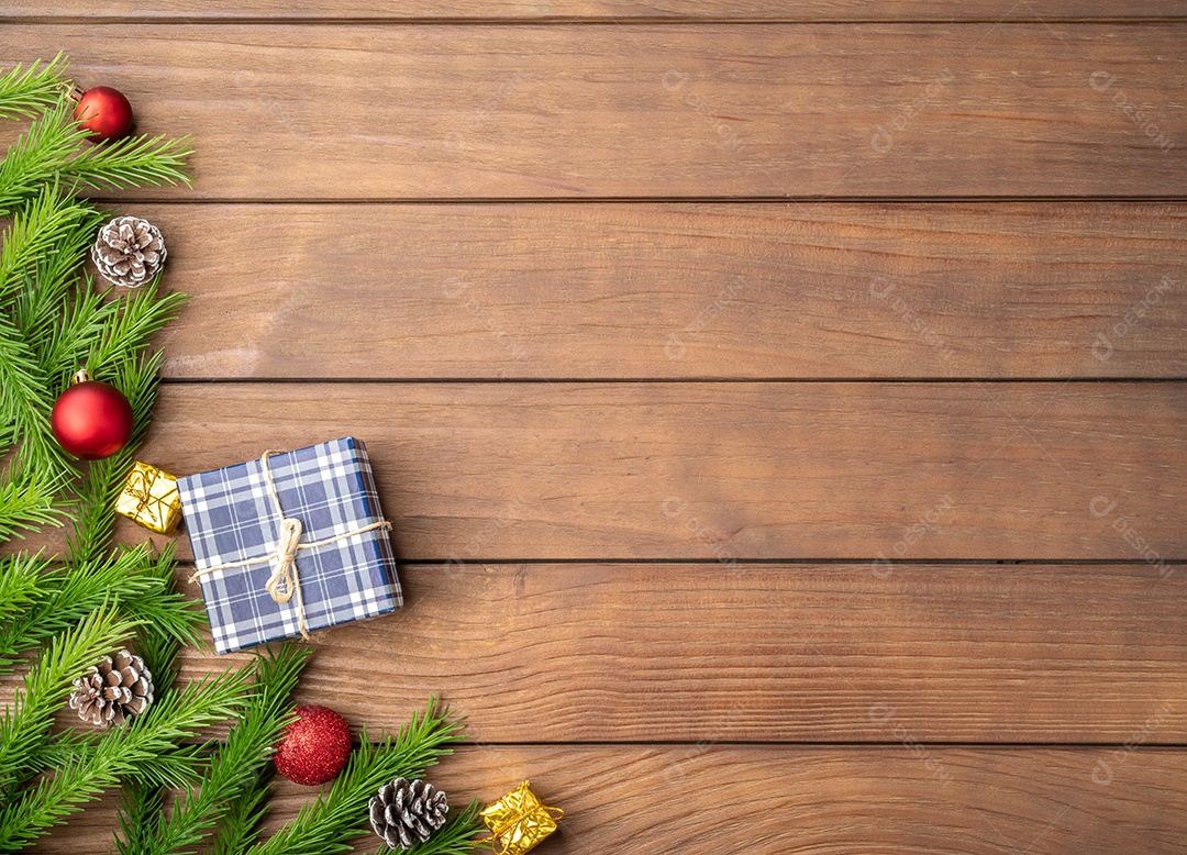 Ramos de pinheiro, bolas de natal e pinhas sobre a mesa de madeira