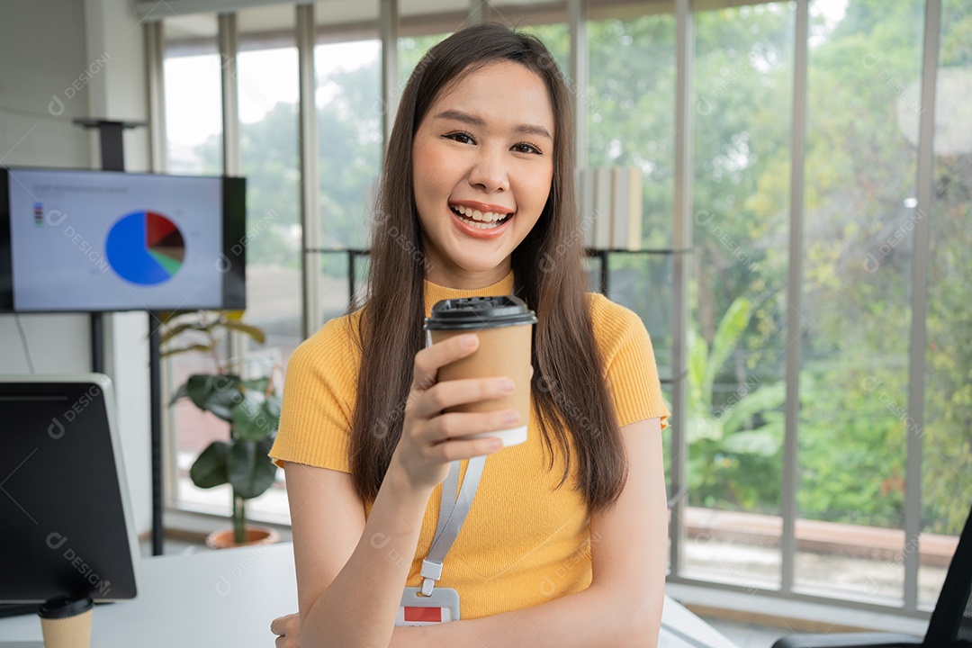 Jovem asiática feliz empresária segurando uma xícara de café