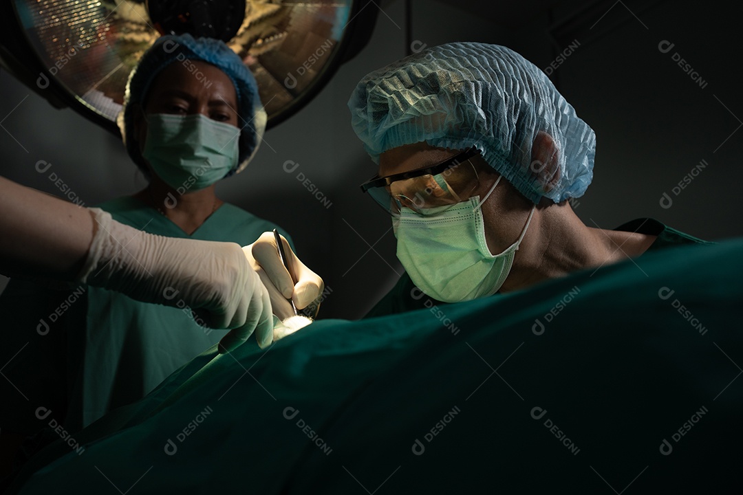 Equipe de cirurgiões profissionais asiáticos realizando cirurgia na sala