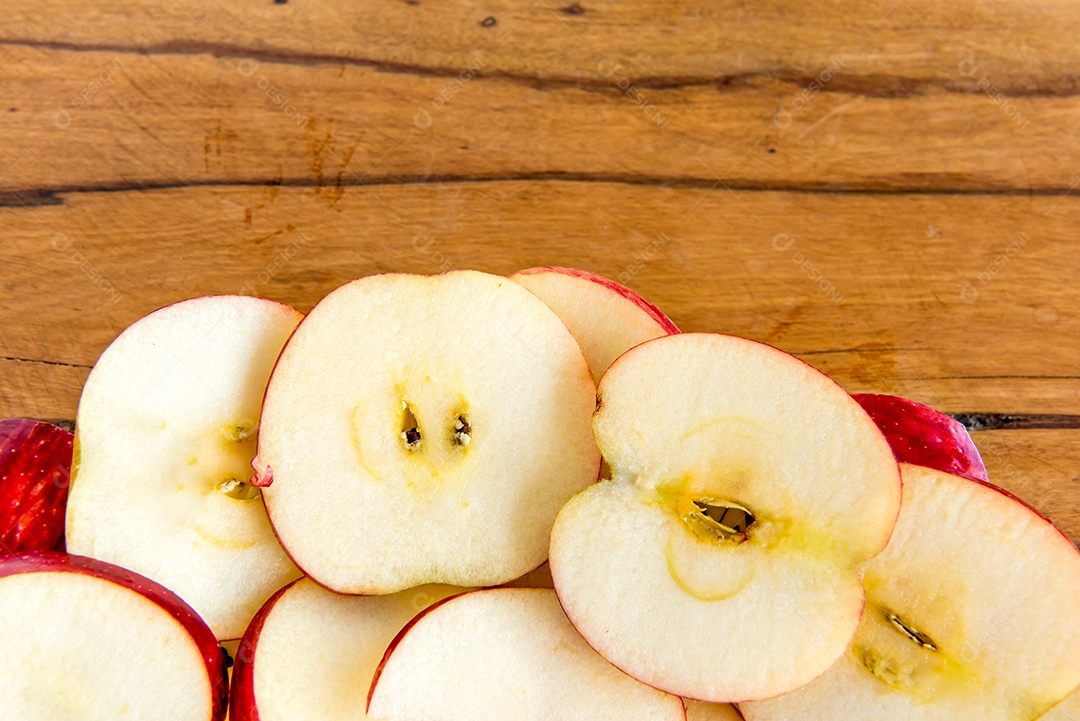 Maçã fatiada em fundo de madeira