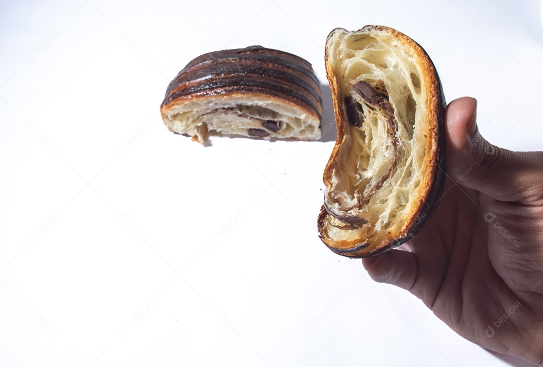 Mãos pessoa segurando pão chocolate, croissant de chocolate sobre prato branco