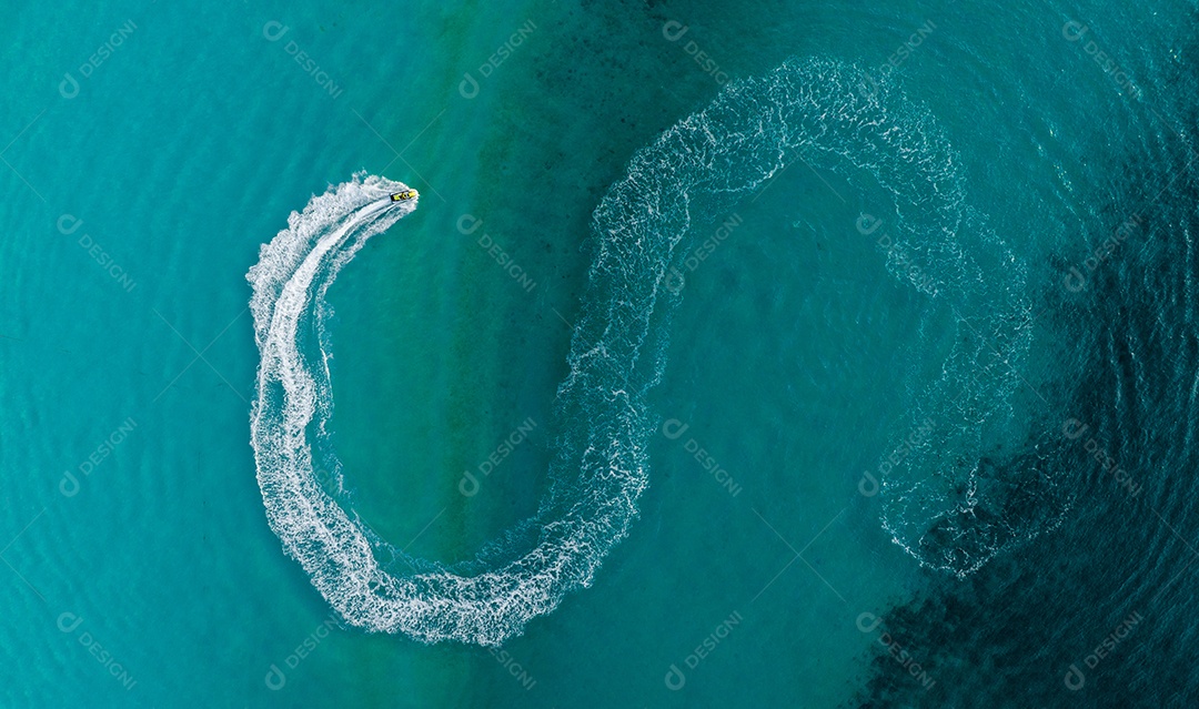 Turista jogando um jet ski ou scooter acima de scooter de água rápida no mar, andando em círculo fazendo belas ondas brancas de espuma no Oceano Pacífico claro. turquesa clara na praia tropical. ação de vista superior