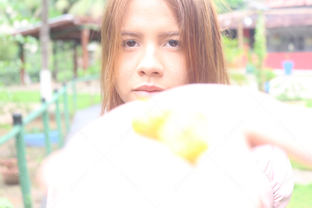 Mulher desfocada, segurando algumas pitangas na mão