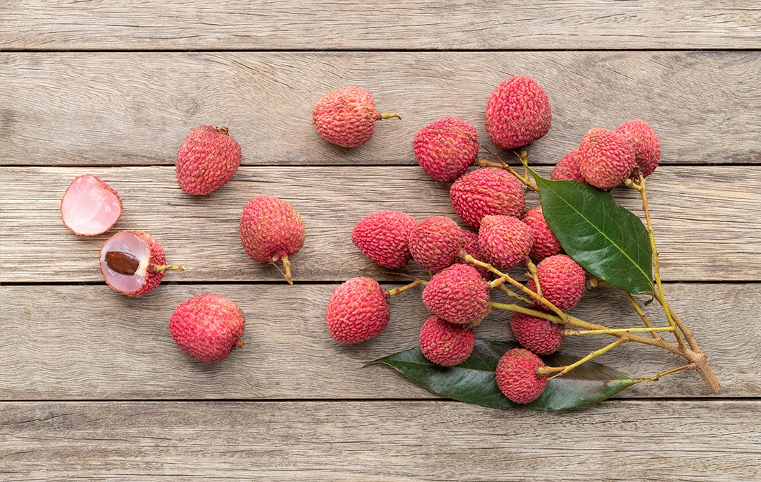 Lichias com frutas cortadas sobre a mesa de madeira.