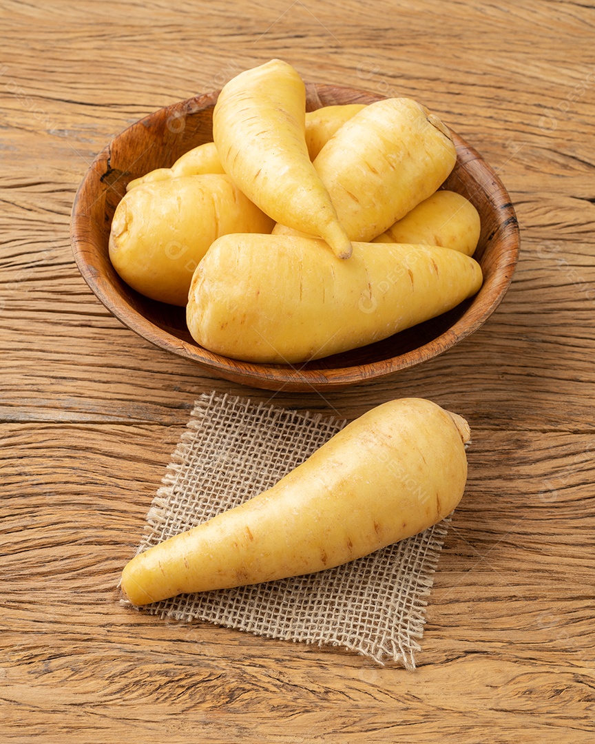 Mandioquinha crua ou arracacha em uma tigela sobre a mesa de madeira