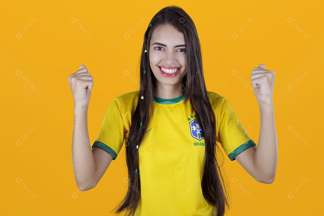 Linda mulher torcedora brasileira sobre fundo isolado amarelo