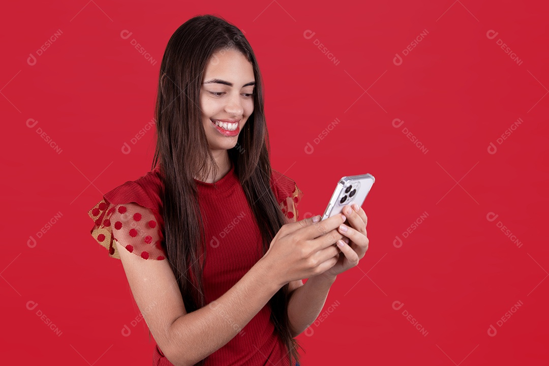 Linda mulher jovem mexendo em seu celular smartphone sobre fundo vermelho
