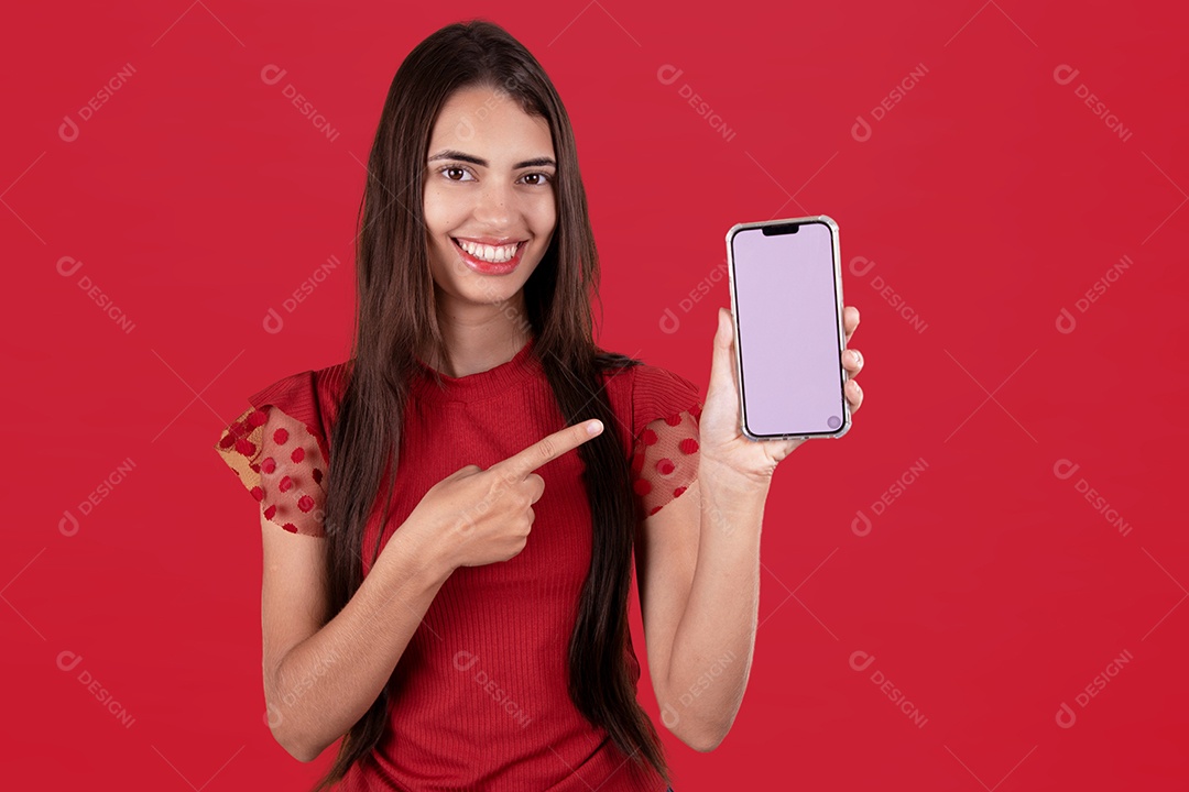 Linda mulher jovem sorridente segurando celular smartphone sobre fundo vermelho