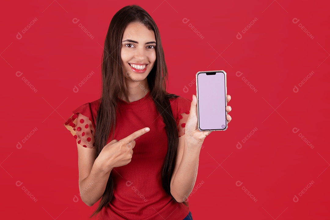 Linda mulher jovem sorridente segurando celular smartphone sobre fundo vermelho
