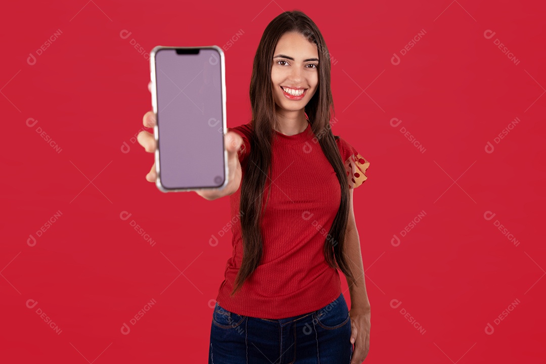 Linda mulher jovem sorridente segurando celular smartphone sobre fundo vermelho