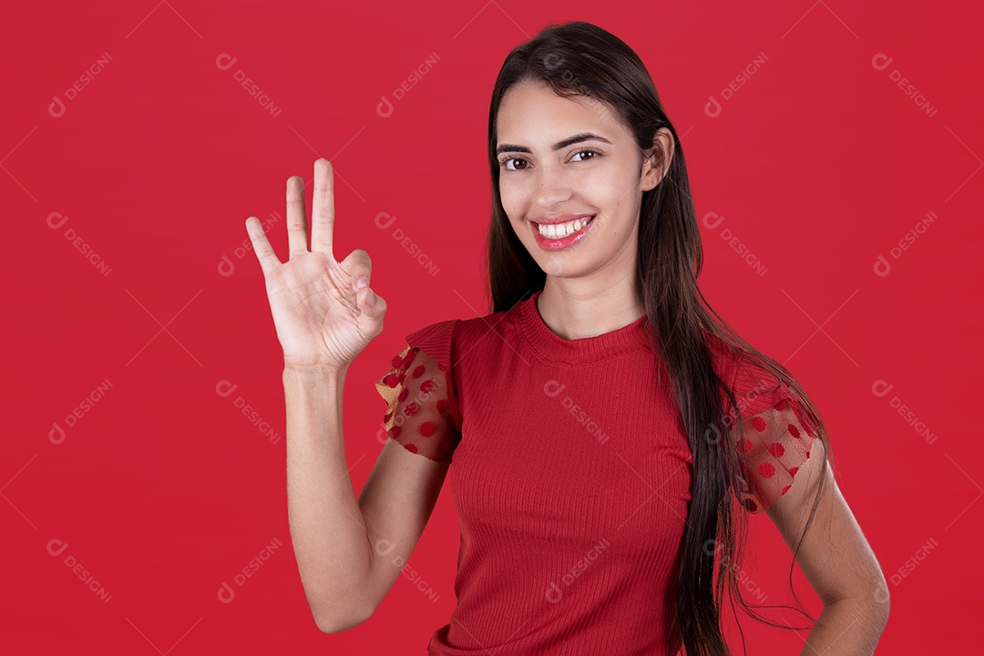 Linda mulher jovem garota sorridente fazendo gesto OK sobre fundo isolado vermelho