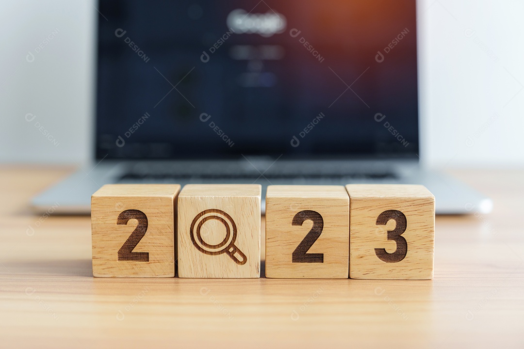 Bloco de 2023 com ícone de lupa contra o fundo do laptop.