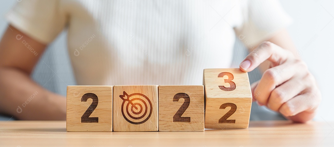 Mão de mulher mudar 2022 para 2023 bloco com ícone de alvo de dardos. Meta