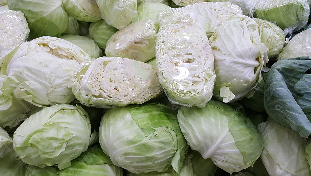 Repolho fresco empilhado à venda no mercado.