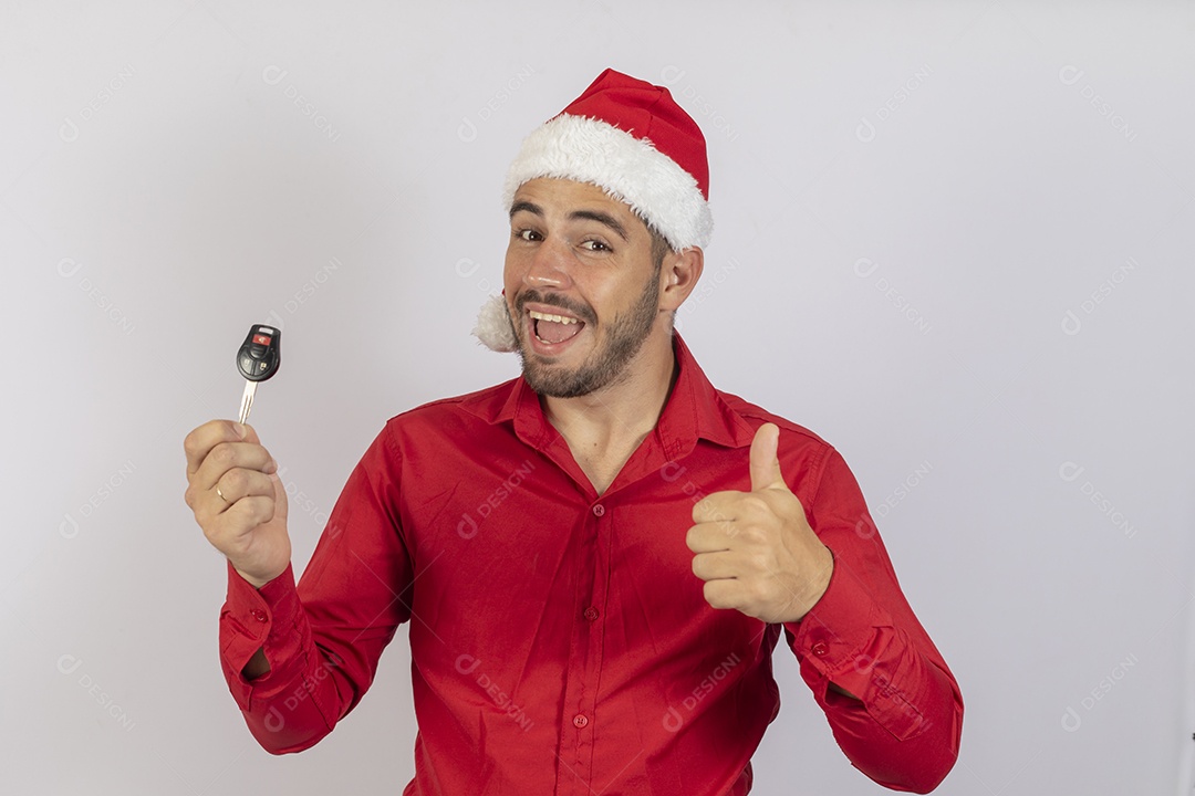 Homem jovem usando gorro Papai Noel segurado chave de carro