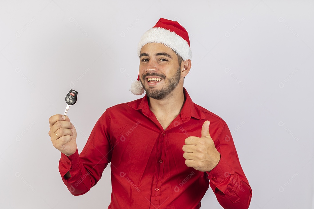 Homem jovem usando gorro Papai Noel segurado chave de carro