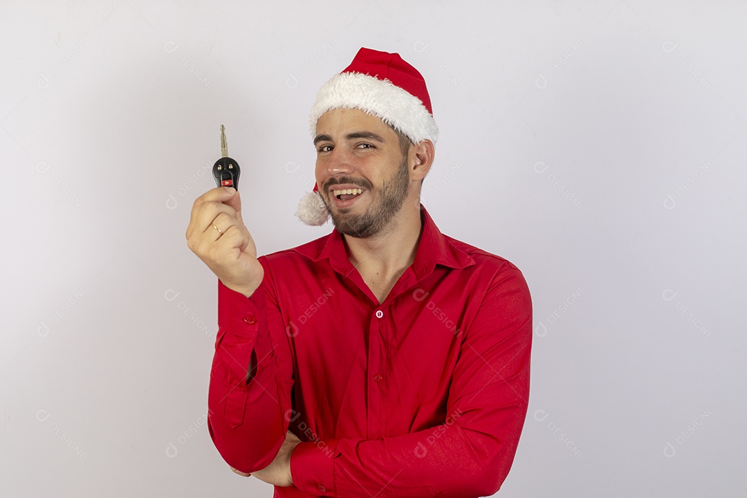 Homem jovem usando gorro Papai Noel segurado chave de carro