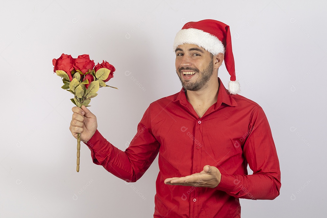 Homem jovem usando gorro Papai Noel segurando buquê flores sobre fundo branco