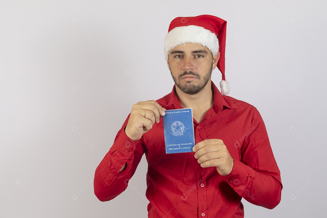 Homem jovem usando gorro Papai Noel segurando carteira de trabalho sobre fundo branco