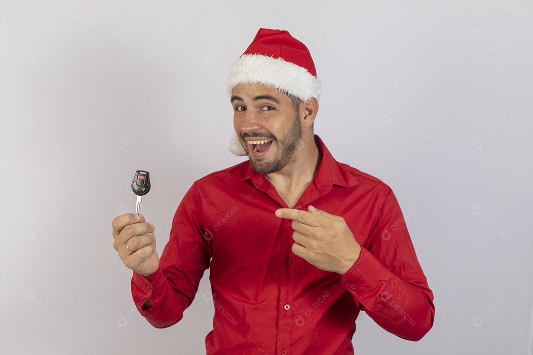 Homem jovem usando gorro Papai Noel segurado chave de carro