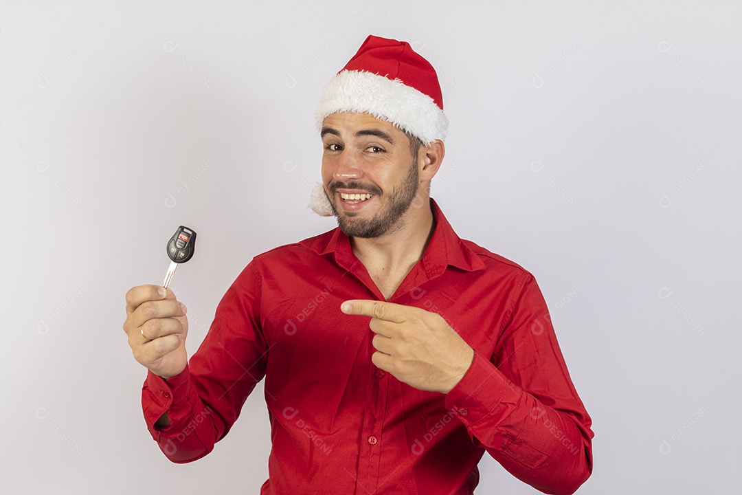 Homem jovem usando gorro Papai Noel segurado chave de carro