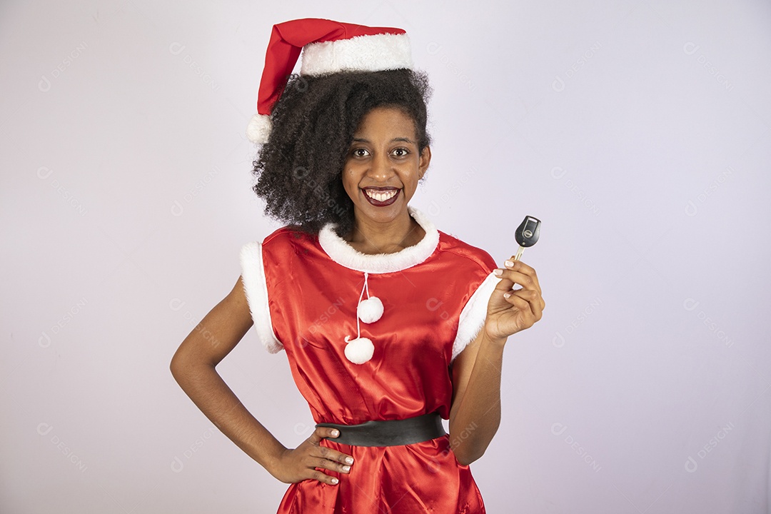 Mulher jovem usando gorro segurando chave de carro Papai Noel sobre fundo branco