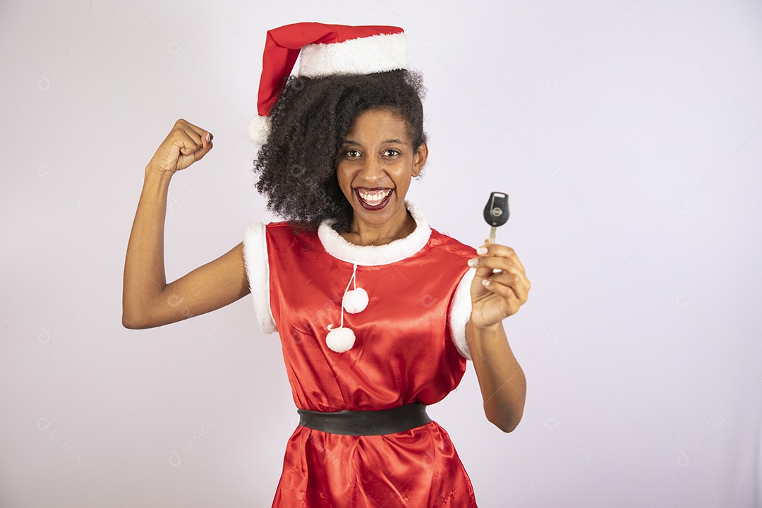 Mulher jovem usando gorro segurando chave de carro Papai Noel sobre fundo branco