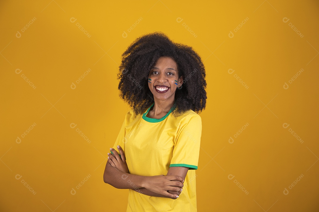 Linda mulher torcedora brasileira cabelo cacheado sobre fundo isolado amarelo