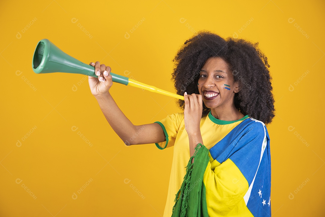 Linda mulher torcedora brasileira cabelo cacheado sobre fundo isolado amarelo