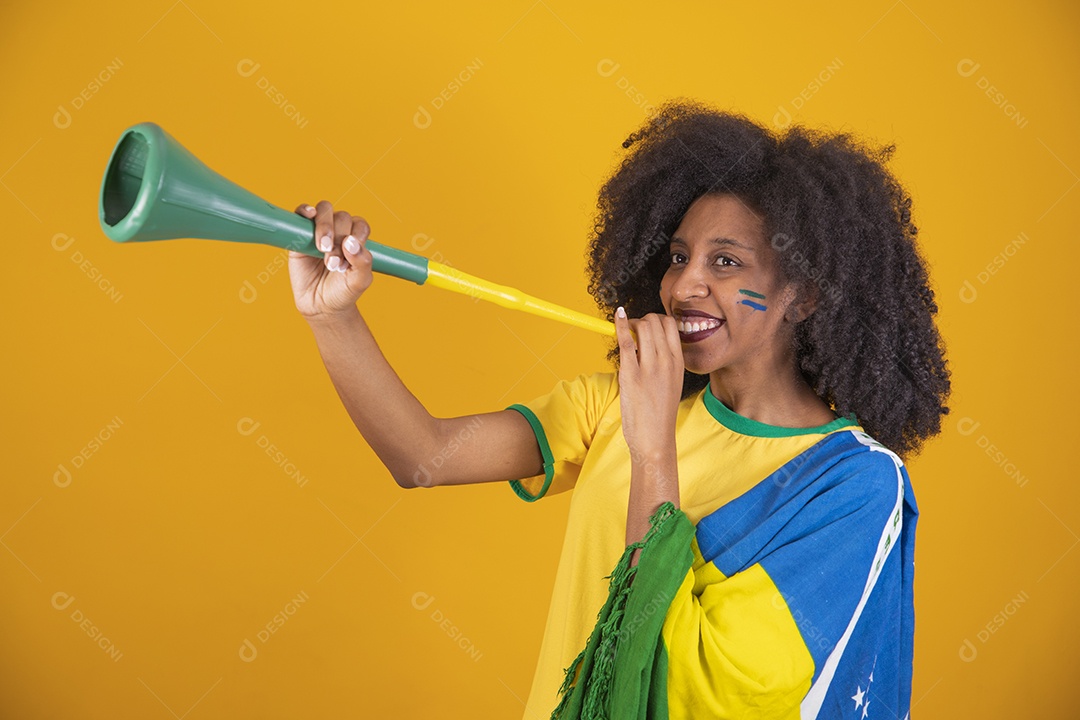 Linda mulher torcedora brasileira cabelo cacheado sobre fundo isolado amarelo