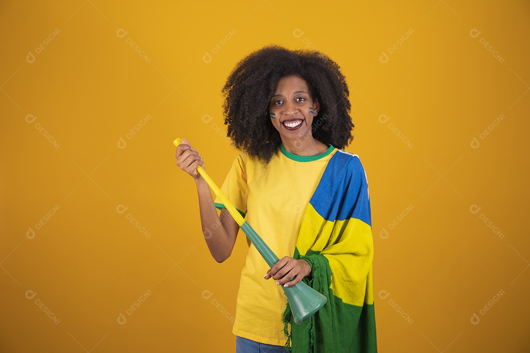 Linda mulher torcedora brasileira cabelo cacheado sobre fundo isolado amarelo