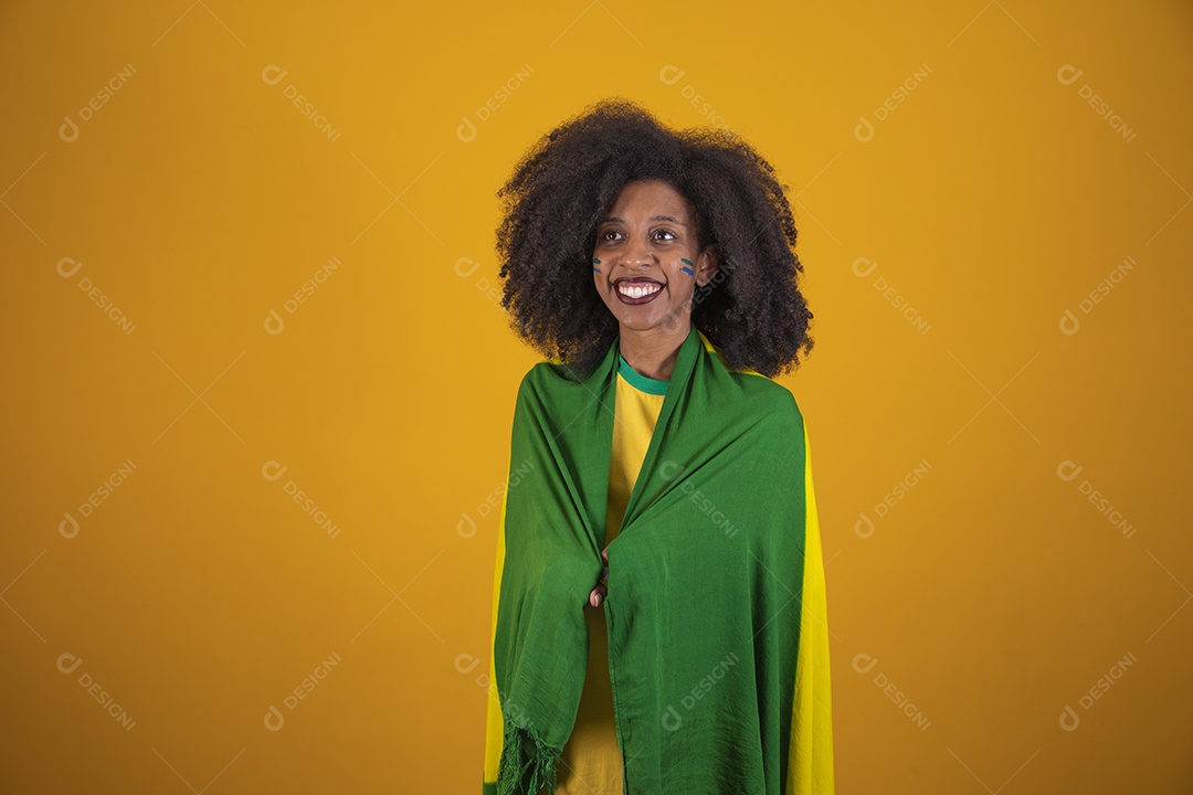 Linda mulher torcedora brasileira cabelo cacheado sobre fundo isolado amarelo