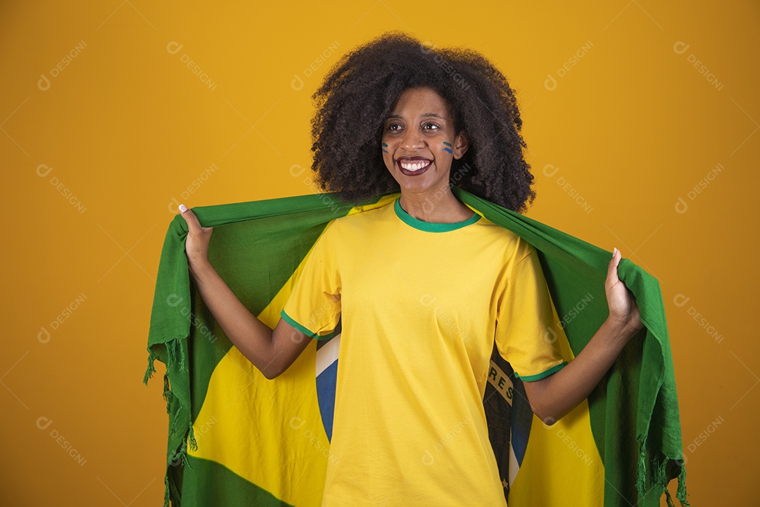 Linda mulher torcedora brasileira cabelo cacheado sobre fundo isolado amarelo