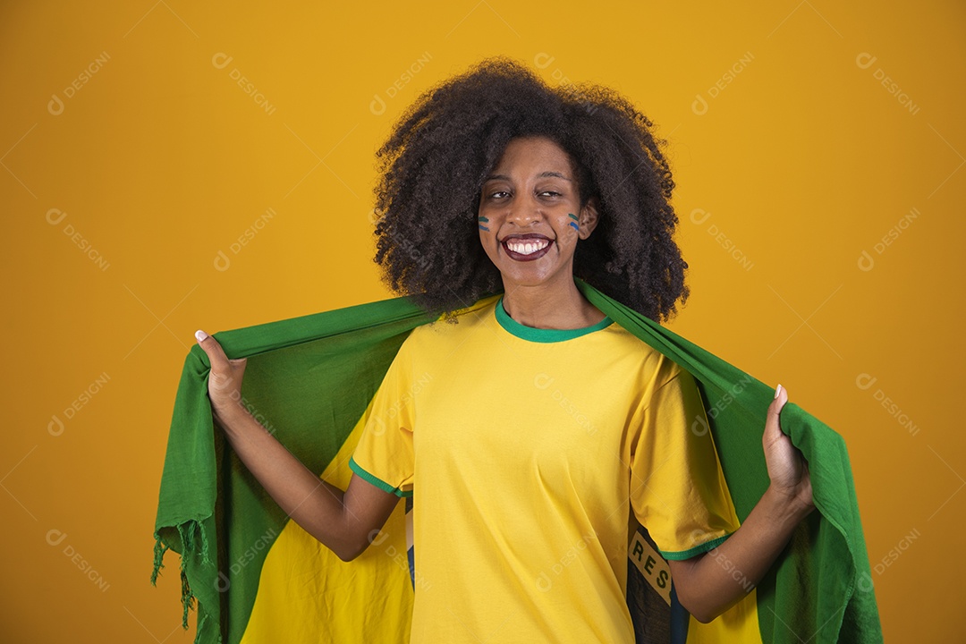 Linda mulher torcedora brasileira cabelo cacheado sobre fundo isolado amarelo