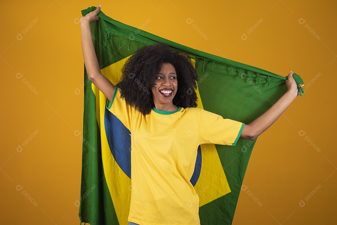 Linda mulher torcedora brasileira cabelo cacheado sobre fundo isolado amarelo