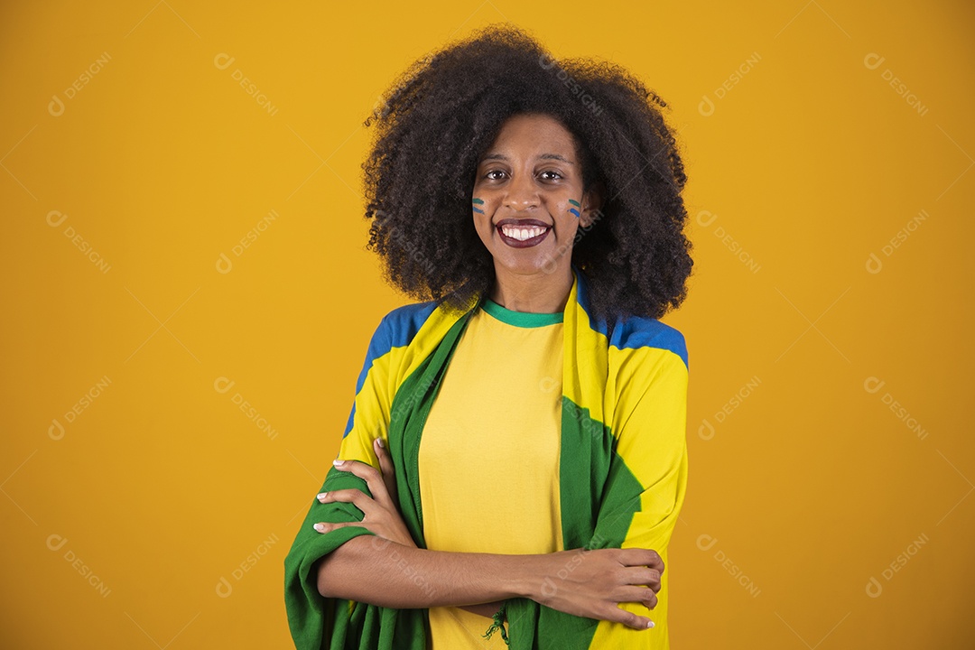 Linda mulher torcedora brasileira cabelo cacheado sobre fundo isolado amarelo