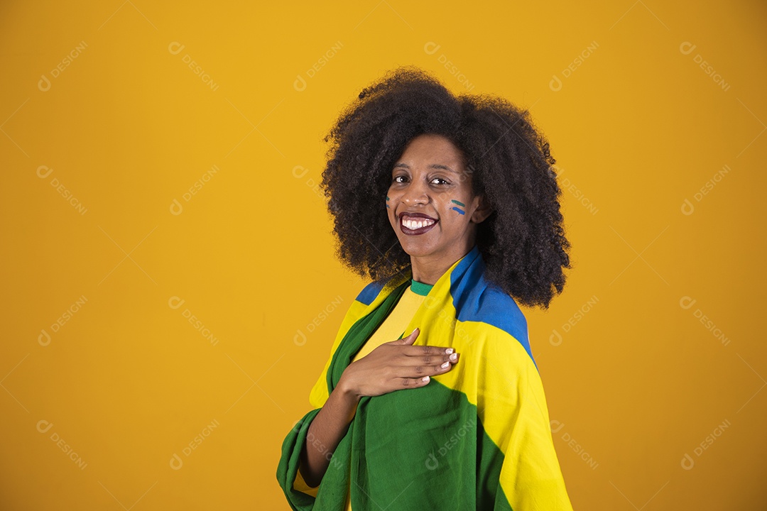 Linda mulher torcedora brasileira cabelo cacheado sobre fundo isolado amarelo