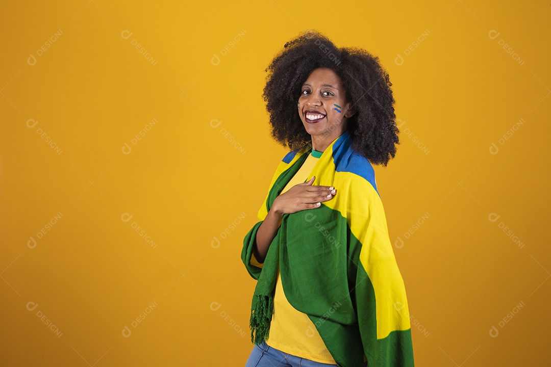 Linda mulher torcedora brasileira cabelo cacheado sobre fundo isolado amarelo